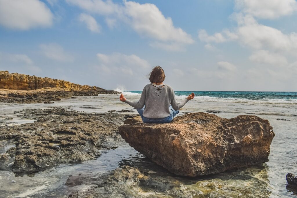 woman on a rock - Spiritual Meaning of Mosquito Bites